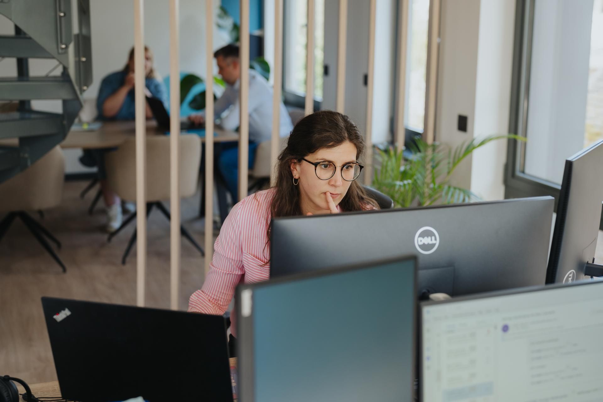 Vrouw werkt geconcentreerd achter computerscherm bij L'Abaco