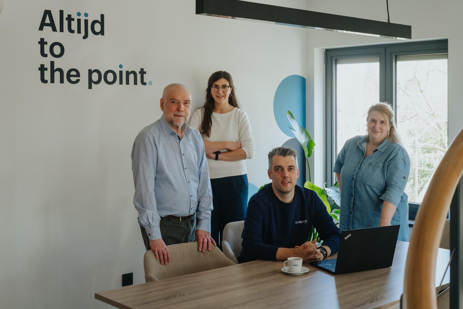 Team van L'Abaco Accountants binnen kantoor naast slogan "Altijd to the point", klaar voor financiële en juridische begeleiding